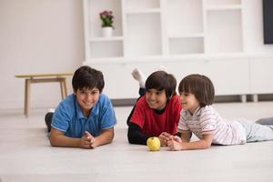 jungen, die spaß mit einem apfel auf dem boden haben foto