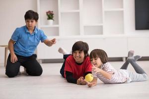 jungen, die spaß mit einem apfel auf dem boden haben foto