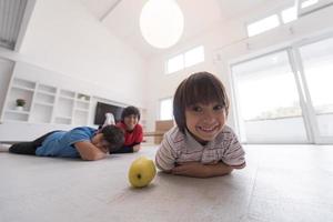 jungen, die spaß mit einem apfel auf dem boden haben foto