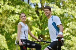 Glückliches Paar, das im Freien Fahrrad fährt foto