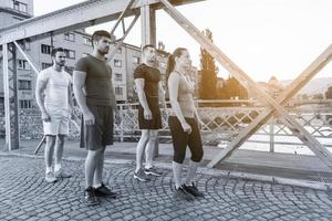 Gruppe junger Leute, die über die Brücke joggen foto