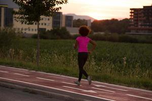 eine junge Afroamerikanerin, die im Freien joggt foto