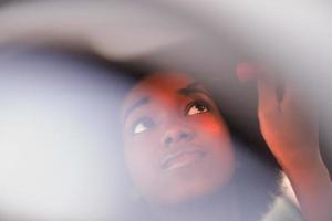 Make-up einer jungen afroamerikanischen Frau im Auto foto