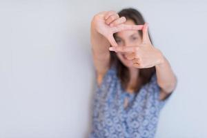 frau, die rahmenhandgeste zeigt foto