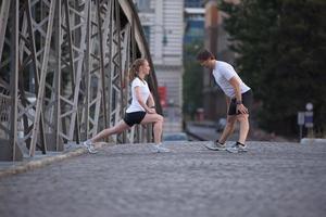 Paar Aufwärmen und Dehnen vor dem Joggen foto