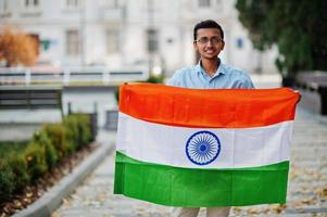 Südasiatischer indischer männlicher Student mit Indien-Flagge im Freien gestellt. foto