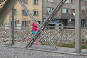 sportliche frau, die auf bürgersteig läuft foto