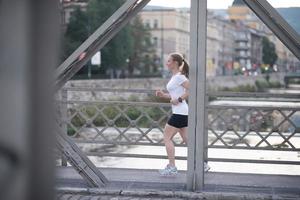 sportliche frau, die auf bürgersteig läuft foto