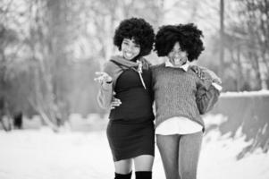 zwei lockige haare afroamerikanerinnen tragen auf pullovern, die am wintertag gestellt werden. foto
