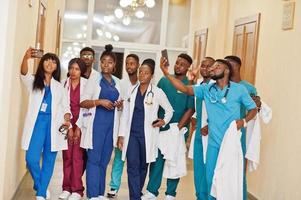 gruppe afrikanischer medizinstudenten im college, die zusammen selfie am telefon machen. foto