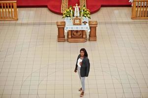 Afroamerikanerin, die in der Kirche betet. Gläubige meditieren in der Kathedrale und spirituelle Gebetszeit. Sicht von oben. foto