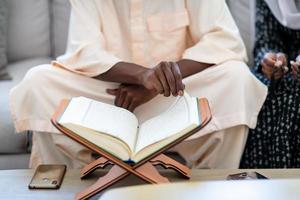 afrikanisches paar zu hause, das koran liest foto