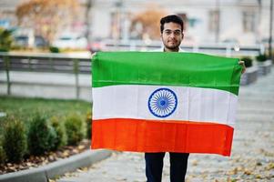 Südasiatischer indischer männlicher Student mit Indien-Flagge im Freien gestellt. foto