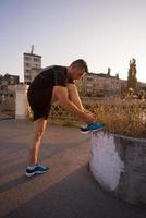 Mann bindet Laufschuhe Schnürsenkel foto