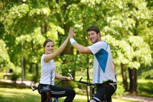 Glückliches Paar, das im Freien Fahrrad fährt foto