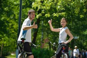 Glückliches Paar, das im Freien Fahrrad fährt foto