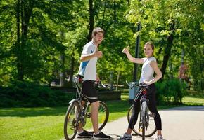 Glückliches Paar, das im Freien Fahrrad fährt foto