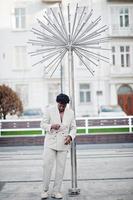 stylischer Afro-Mann im beigen Old-School-Anzug. Modischer junger afrikanischer Mann in Freizeitjacke auf nacktem Oberkörper. foto