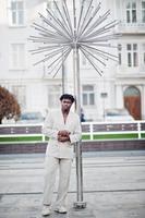 stylischer Afro-Mann im beigen Old-School-Anzug. Modischer junger afrikanischer Mann in Freizeitjacke auf nacktem Oberkörper. foto