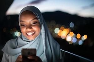 junge muslimische frau auf der straße nachts mit telefon foto