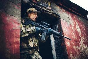 Soldat mit Gewehr in den Ruinen