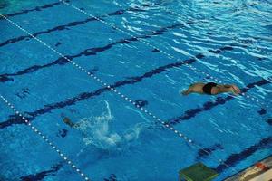 junger Schwimmer beim Schwimmstart foto