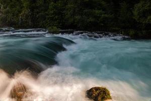 einzelner Stein im wilden Fluss foto