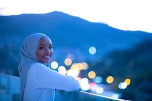 afrikanische moderne muslimische frau in der nacht auf dem balkon foto