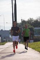 Zwei junge Männer joggen durch die Stadt foto