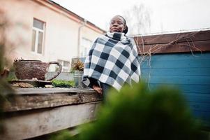 Afrikanische Frau im karierten Umhang posierte im Freien. foto