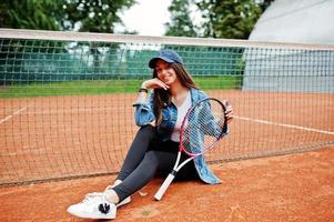 junge sportliche Spielerin mit Tennisschläger auf dem Tennisplatz. foto