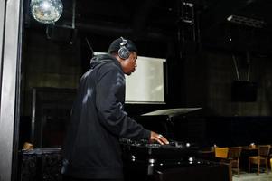 afrikanisch-amerikanischer dj spielt musik auf decks im nachtclub. foto