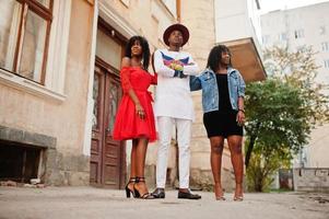 Gruppe von drei stilvollen, trendigen Afro-Frankreich-Freunden posierte am Herbsttag. schwarzafrikanisches Mannmodell mit zwei dunkelhäutigen Frauen. foto