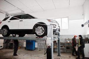 amerikanisches suv-auto auf stand für radausrichtungs-sturzprüfung in der werkstatt der servicestation. foto