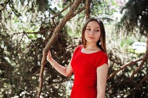 Teenager-Mädchen im roten Kleid posierte im Freien an einem sonnigen Tag. foto