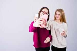 zwei mädchen in lila kleidern, die selfie im studio machen. foto