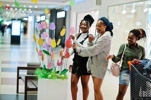 gruppe afrikanischer frauen, die mit einkaufswagen auf einkaufszentrum gehen. foto