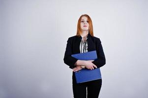 Porträt einer rothaarigen Geschäftsfrau mit gestreifter Bluse und Jacke mit blauem Ordner. foto