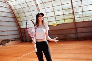 junge sportliche Spielerin mit Tennisschläger auf dem Tennisplatz. foto