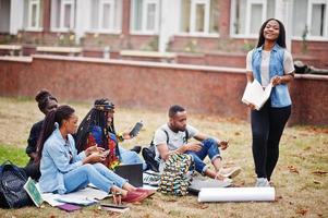 Gruppe von fünf afrikanischen College-Studenten, die gemeinsam Zeit auf dem Campus des Universitätshofs verbringen. Schwarze Afro-Freunde studieren. Thema Bildung. foto