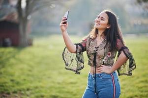 hübsches latino-model-mädchen aus ecuador wear auf jeans posierte auf der straße mit handy. foto