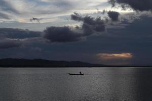 Fischer auf seinem Boot bei Sonnenuntergang. Fischerboot bei Sonnenuntergang foto