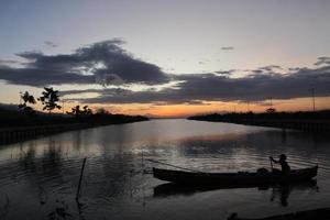 Fischer auf seinem Boot bei Sonnenuntergang. Fischerboot bei Sonnenuntergang foto