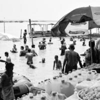 garh mukteshwar, oben, indien, 11. juni 2022 - menschen nehmen anlässlich von nirjala ekadashi ein heiliges bad, einen blick auf garh ganga brij ghat, der ein sehr berühmter religiöser ort für hindus-schwarz und weiß ist foto