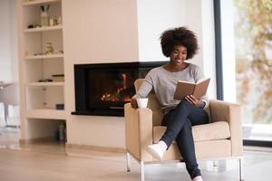 schwarze frau liest buch vor kamin foto