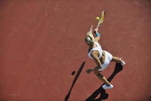 junge Frau spielt Tennis im Freien foto