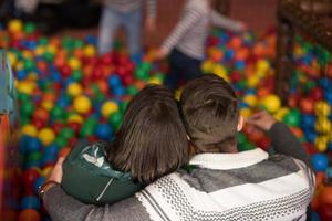 junge eltern mit kindern in einem kinderspielzimmer foto