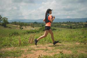 junge aktive Trailläuferinnen auf dem Gipfel eines Berges am Nachmittag, Ultra-Marathonläufer, die im Freien unterwegs sind foto