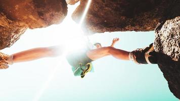 niedriger winkel nahaufnahme junge kaukasische sportliche frau trainingsschritte auf felsklettern im freien bei sonnigem heißem wetter allein. inspirierende aktive sportliche Aktivitäten für starke Frauen im Freien foto