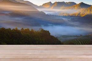 Holztischplatte auf verschwommenem Hintergrund der Teeplantage - kann zur Präsentation Ihrer Produkte verwendet werden foto
